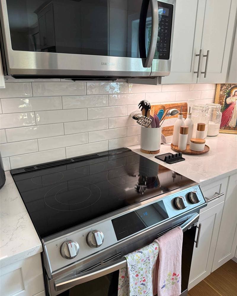 A clean white kitchen with a stainless range, microwave, and subway-tile backsplash in Jefferson Township, NJ.