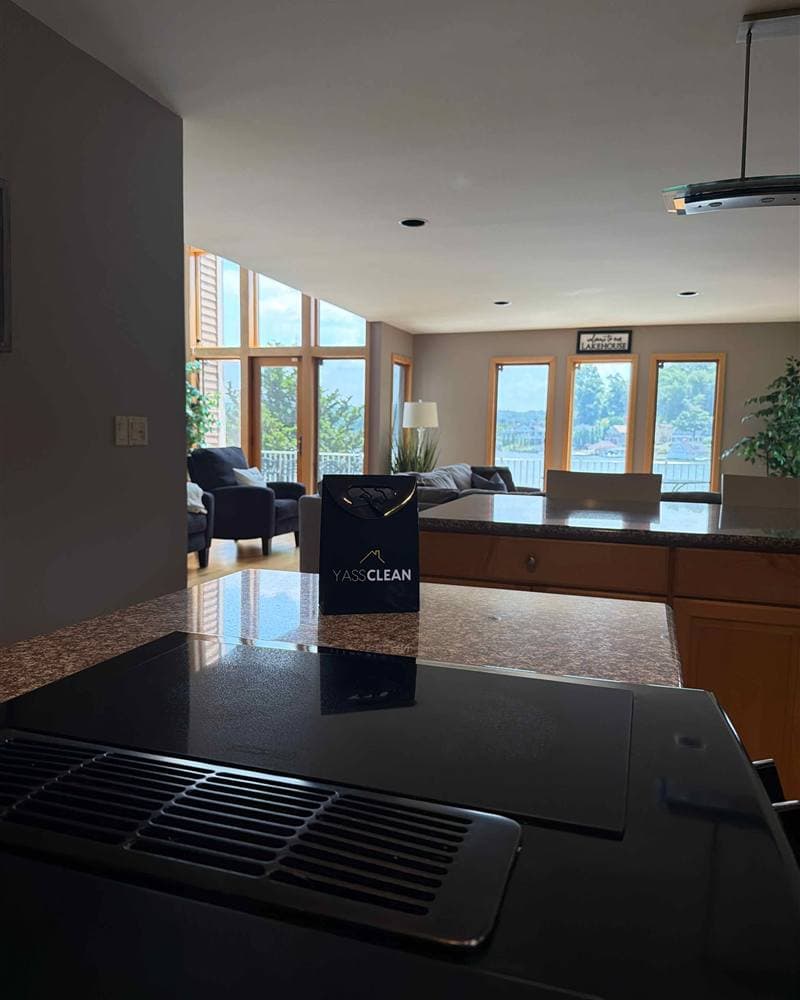A granite kitchen island with a YassClean bag and a lake view, spotless after a deep clean.