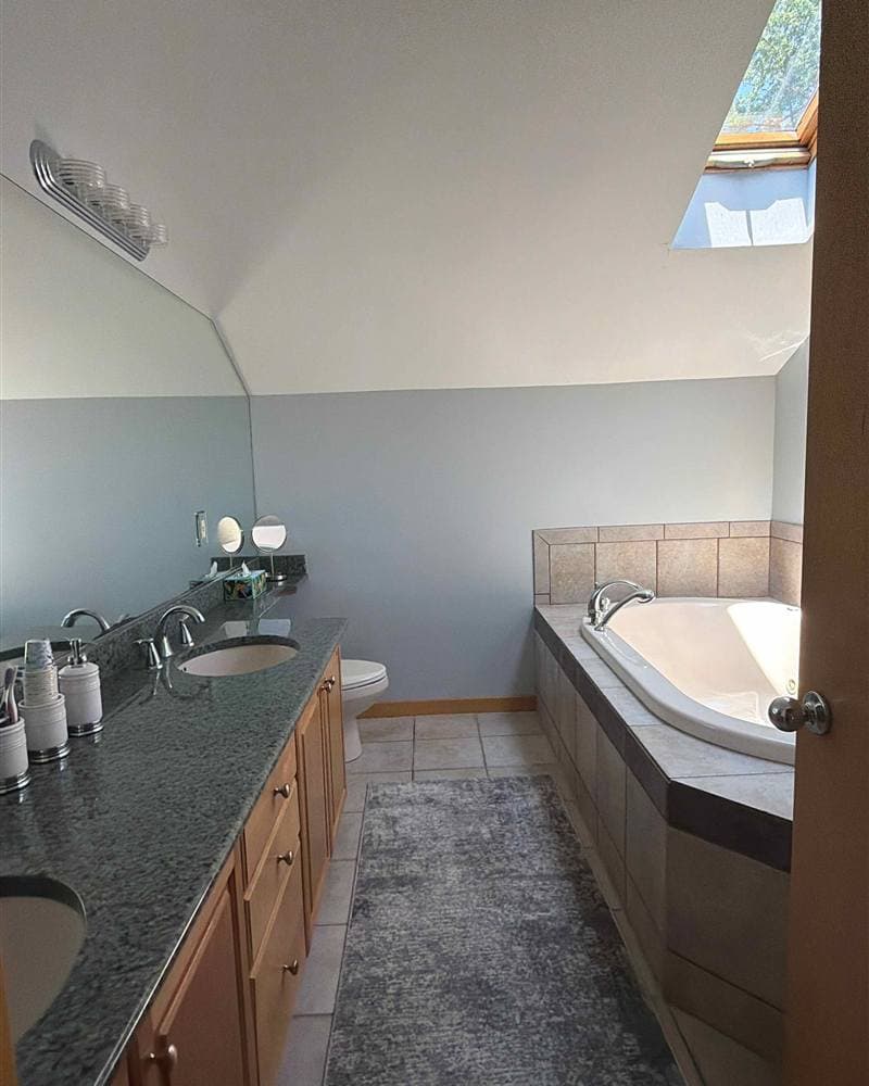 Clean master bathroom with granite double vanity and soaking tub after a deep clean in Hopatcong, NJ