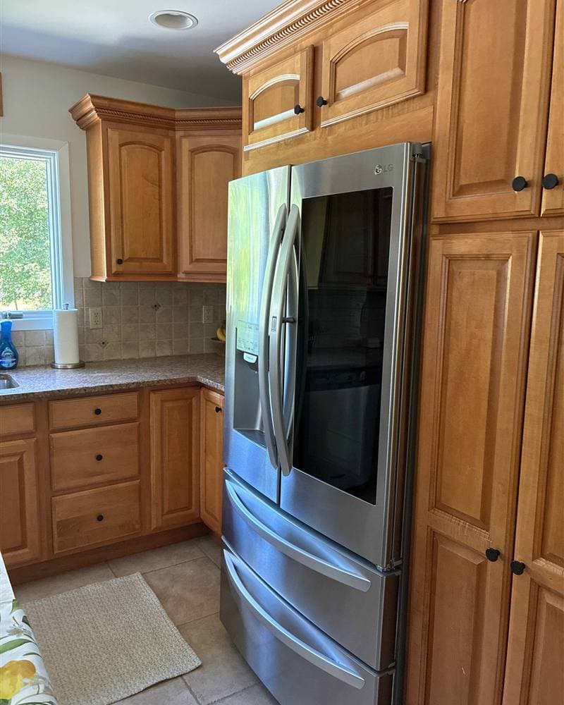 Polished stainless steel refrigerator and wooden cabinets after a kitchen cleaning in Boonton, NJ