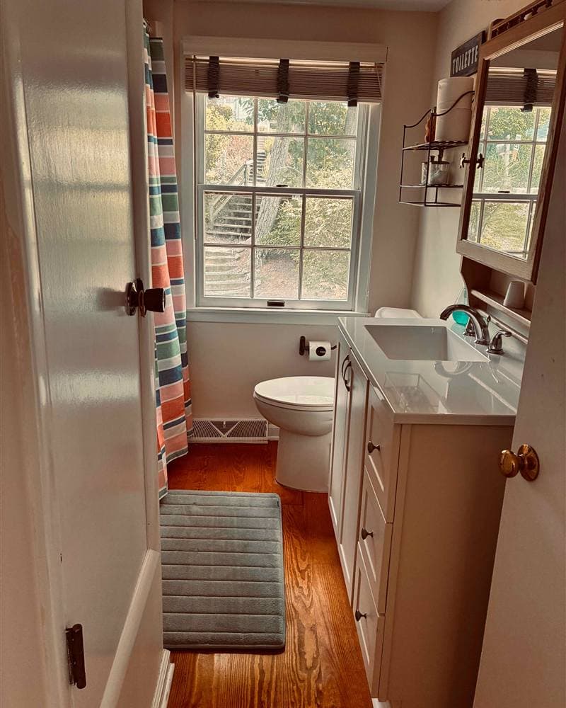 Tidy bathroom with white vanity, sink, and toilet after a cleaning in Branchville, NJ