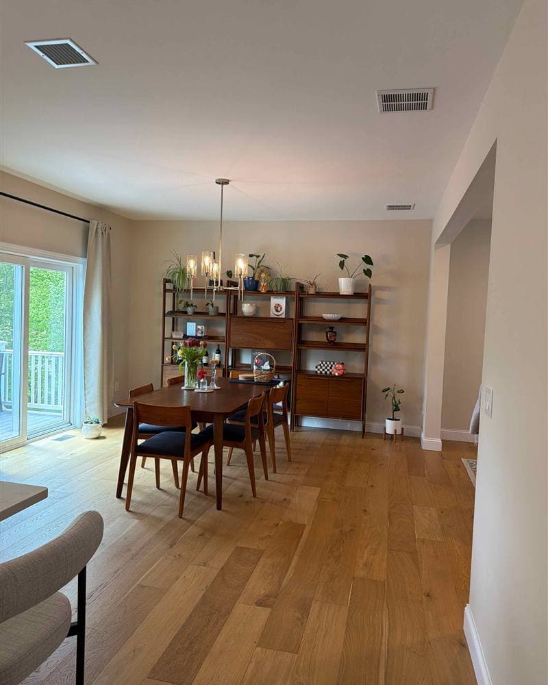 Clean dining room with hardwood floors and shelving unit after a house cleaning in Jefferson, NJ