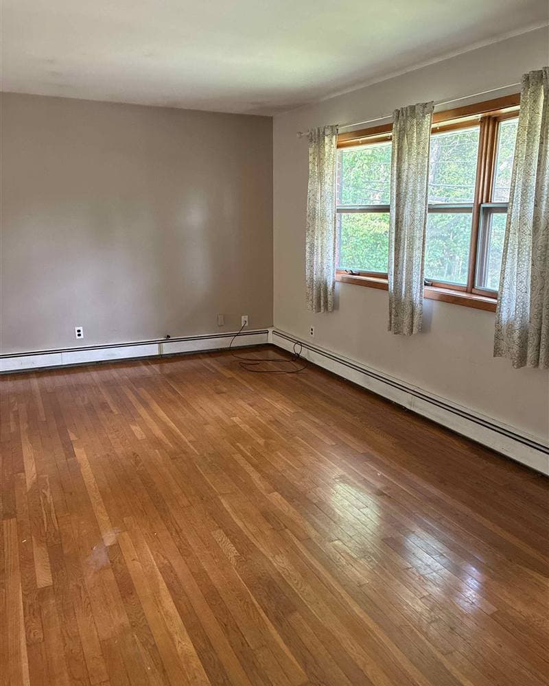 Bright empty room with gleaming hardwood floors and clean windows after a move-out clean in Newton, NJ