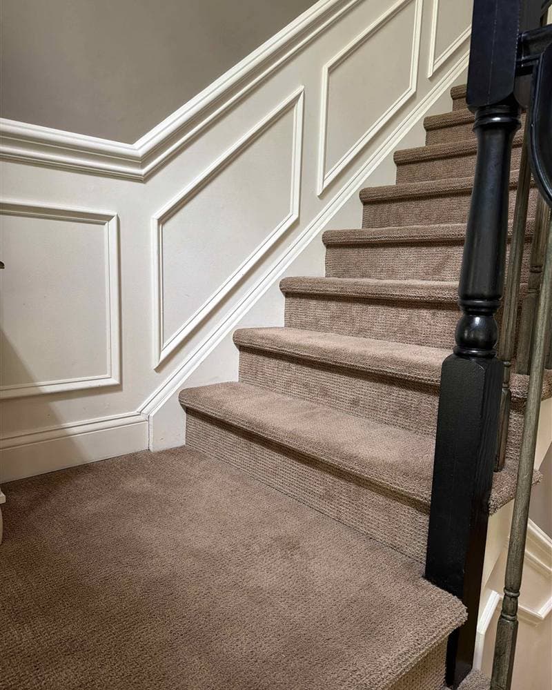 Freshly vacuumed carpeted staircase with white wainscoting in a Rockaway, NJ home